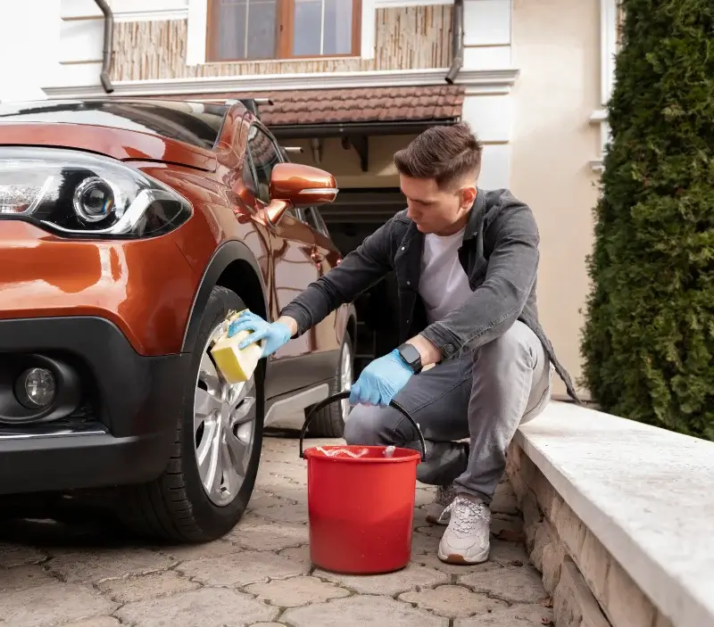 Lavage auto à domicile Les Deux Alpes : professionnel intervenant sur un véhicule